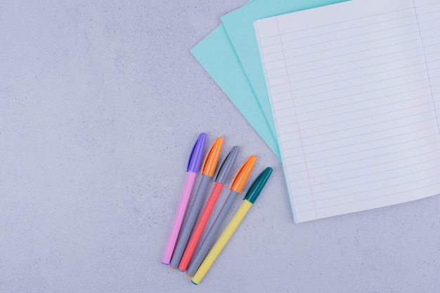 Multicolor pens and a piece of checked blank paper.