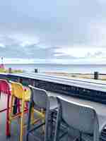 Foto gratuita sedie multicolori sulla terrazza di un caffè in riva al mare