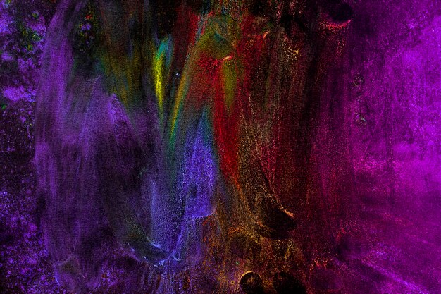 Разноцветные цвета Холи, испачканные рукой на черном фоне