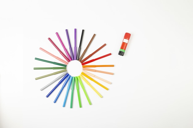 Multicolored marker pens in the form of the sun on a white background