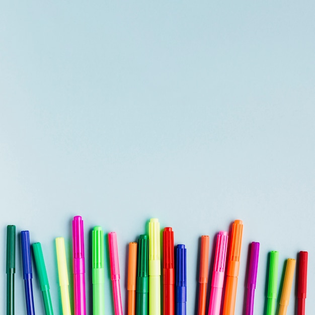 Multicolored markers on blue table