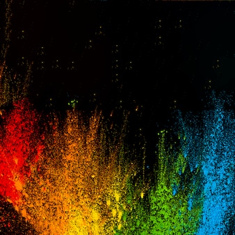 Multicolored rainbow style holi colors arranged against black background