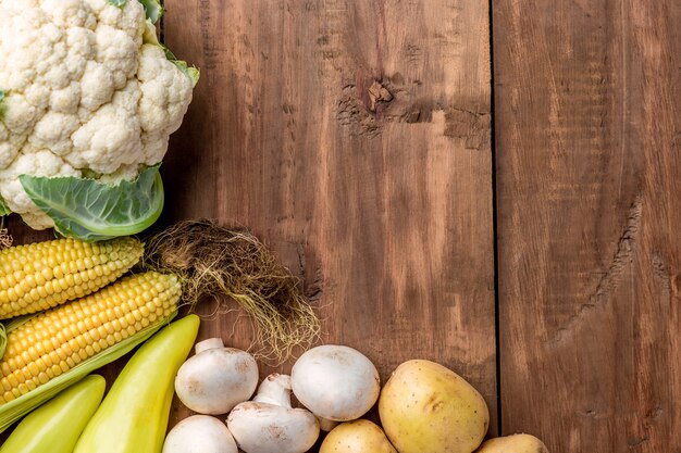 The multicolored vegetables on wooden table background