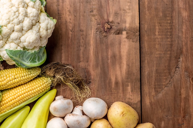 The multicolored vegetables on wooden table background