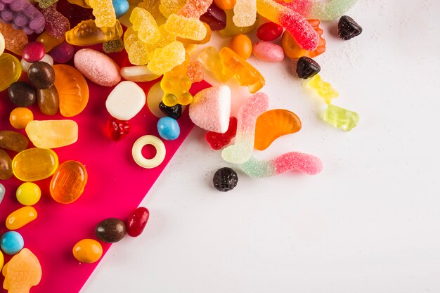 Multicolored winegums on white and fuchsia background