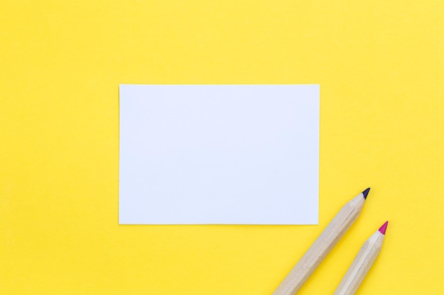 Free photo multicolored wooden pencils and piece of paper on a yellow background