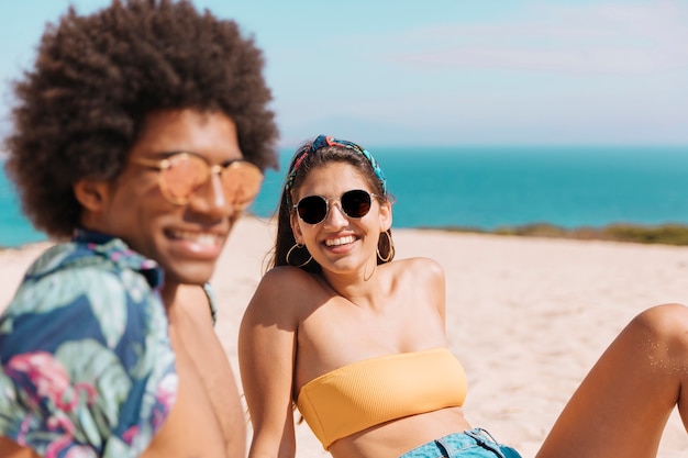 Multicultural couple resting on beach