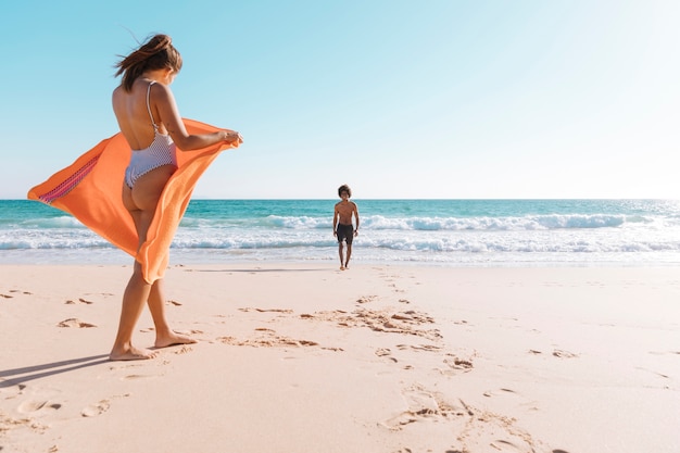 Foto gratuita coppia multiculturale che riposa in riva al mare