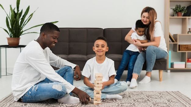 Многокультурная семья играет в деревянную башню