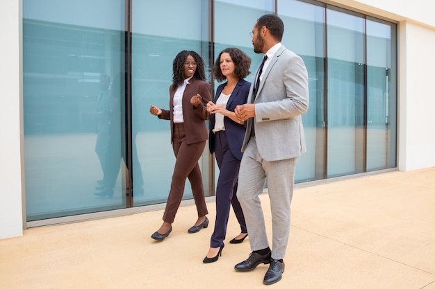 Multiethnic business colleagues walking and talking