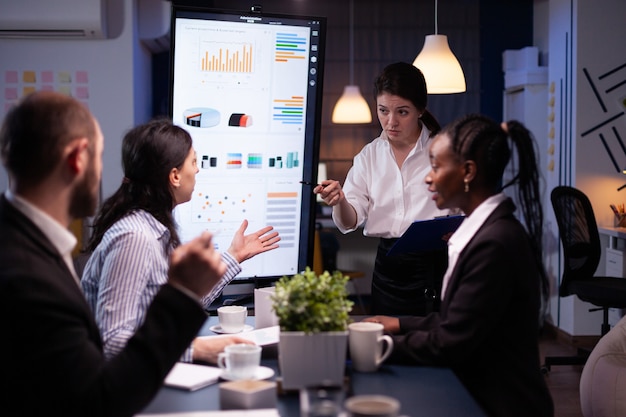 Multiethnic businesspeople discussing financial company solution sitting at conference table