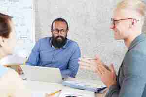 Free photo multiethnic colleagues collaborating at work meeting in office