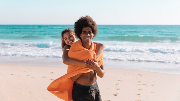 多民族のカップルがビーチで抱きしめる