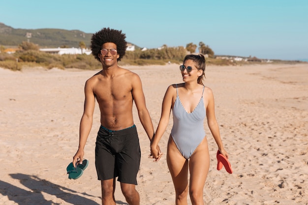 Многонациональное пара в купальных костюмах на пляже