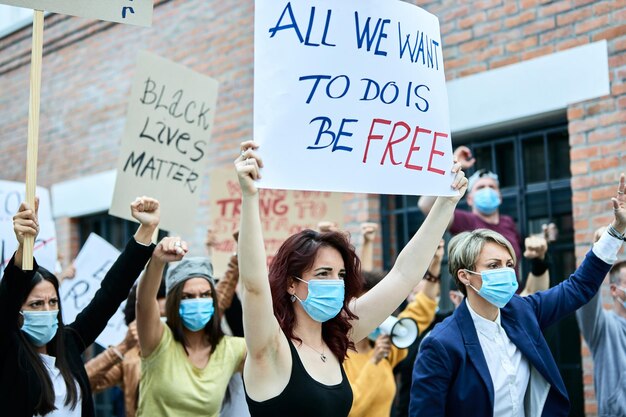 Многонациональная толпа людей в защитной маске во время акции протеста Black Lives Matter