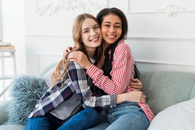 Multiethnic friends embracing and looking at camera 