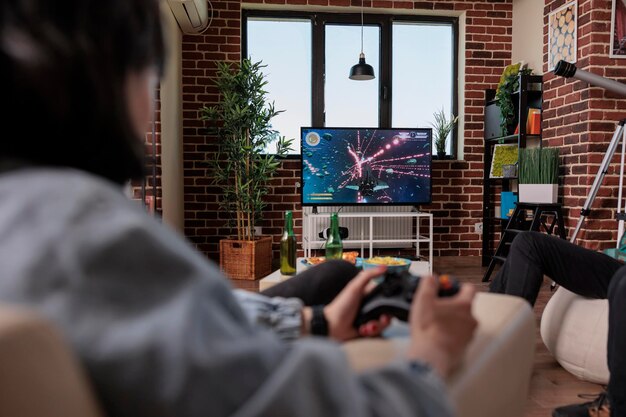 Multiethnic group of people playing online video games on tv console, gaming competition with controller. Friends having fun with game play on television, celebrating friendship event.