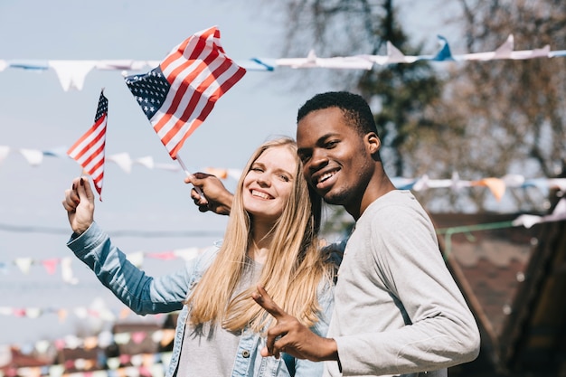 Multiethnic man and woman with American flags