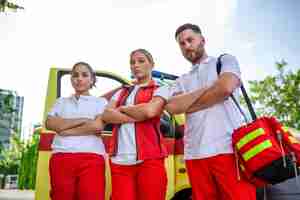 Бесплатное фото Мультиэтнические фельдшеры стоят у машины скорой помощи врач скорой помощи и медсестра стоят перед машиной скорой помощи
