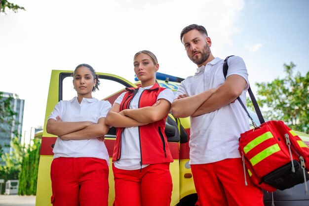 Multiethnic paramedics standing at the fromt of an ambulance Emergency doctor and nurse standing in front of ambulance