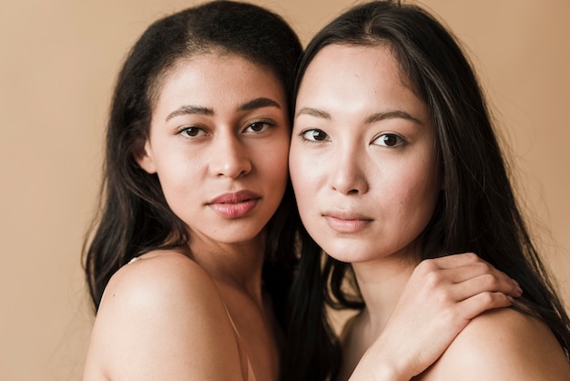 Multiethnic sensual women hugging and looking at camera