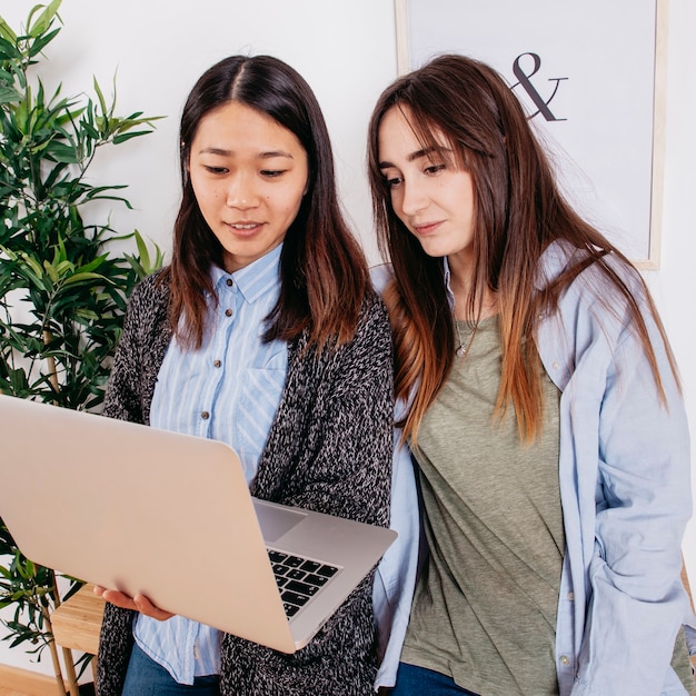 Free photo multiethnic women with notebook in office