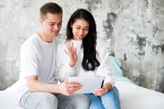 Multiethnic young couple having video chat on tablet