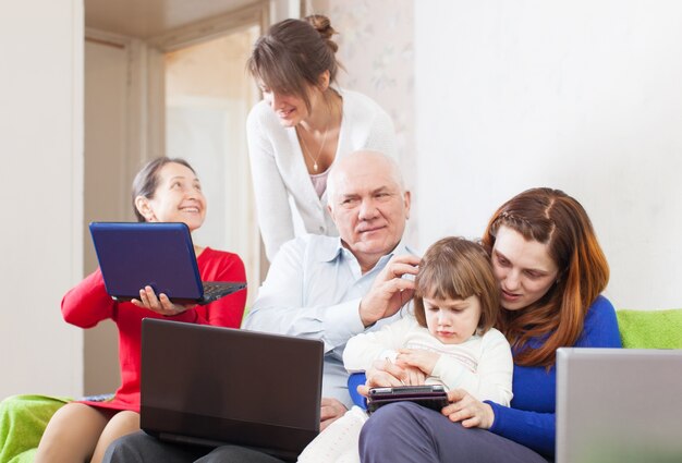 Семья с несколькими поколениями использует несколько портативных электронных устройств