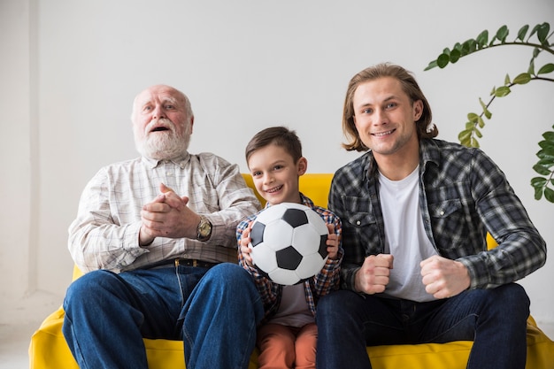 Foto gratuita uomini multigenerazionali che guardano il calcio a casa