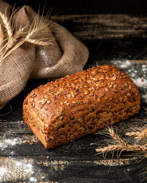 multigrain bread with flour and wheat on table