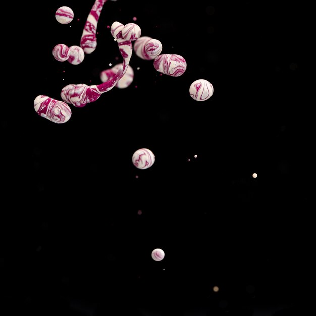Multiple abstract acrylic balls in water on black background