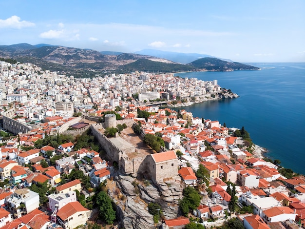 Multiple buildings and fort, green hills on the background in Kavala, Greece