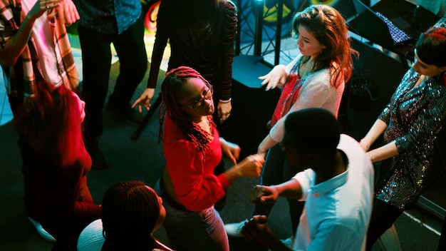 Più persone che ballano in discoteca, si divertono insieme sulla pista da ballo e fanno festa. giovani funky che si godono la vita notturna in discoteca con gli amici, concetto di clubbing. tiro a mano libera.