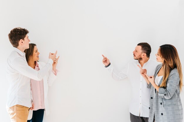 Multiracial group of coworkers pointing at wall