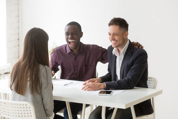 Multiracial hr managers laughing at funny joke interviewing woman applicant