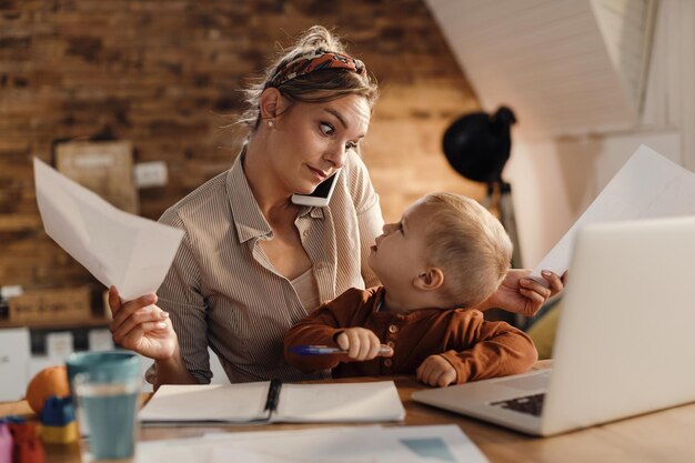 Multitasking working mother with small son at home