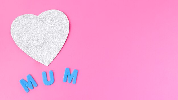 Mum inscription with paper heart on table