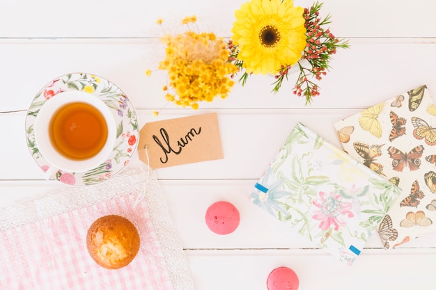 Foto gratuita iscrizione di mamma con tazza di tè e fiori