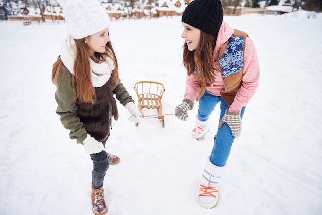 Mummy and daughter pulling sled together