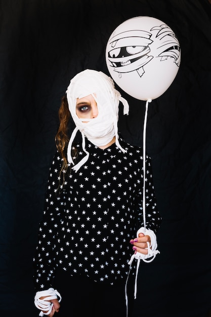 Mummy girl with bandages holding balloon
