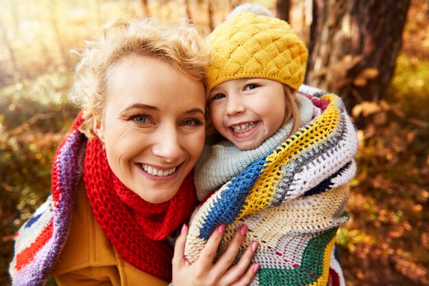 Mummy is covering daughter by scarf