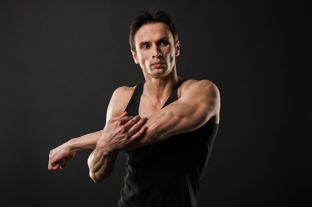 Muscled athletic man warming up before exercising