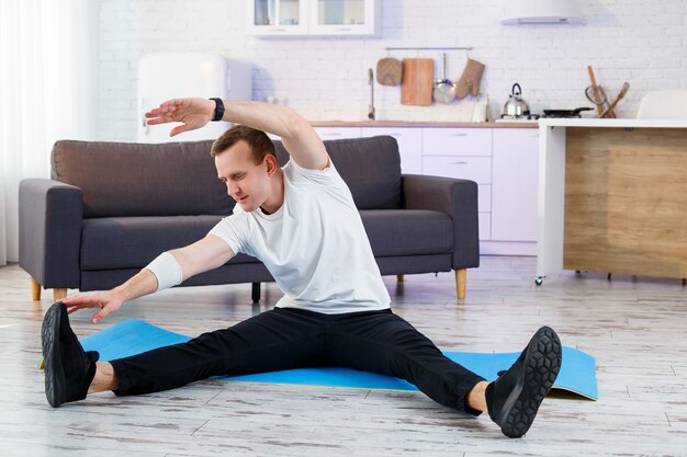 Premium Photo Muscular Athletic Man In A T Shirt Doing Warm Up Exercises At Home Doing Sports At Home During The Quarantine Period Fitness Outside The Gym