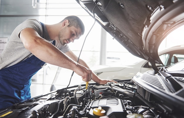 筋肉の自動車サービス労働者が車両を修理します。