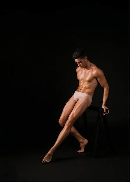 Free photo muscular dancer leaning on barre