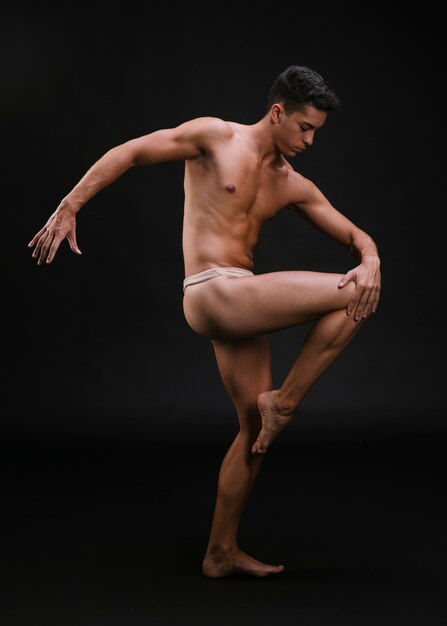 Muscular dancer stretching leg