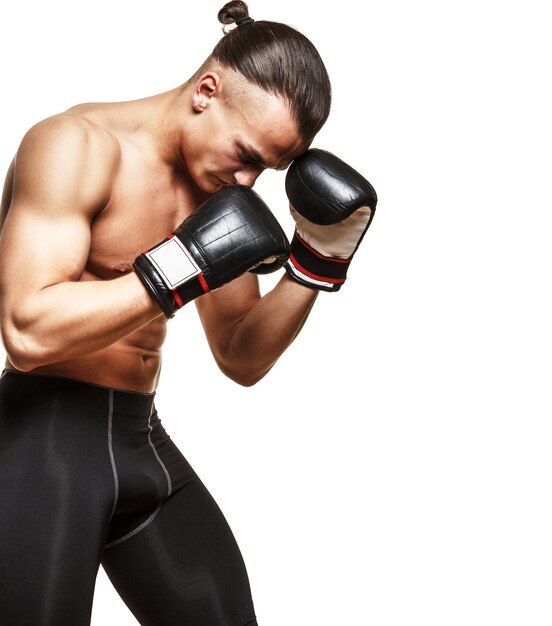 Muscular fighter in boxing gloves on white background