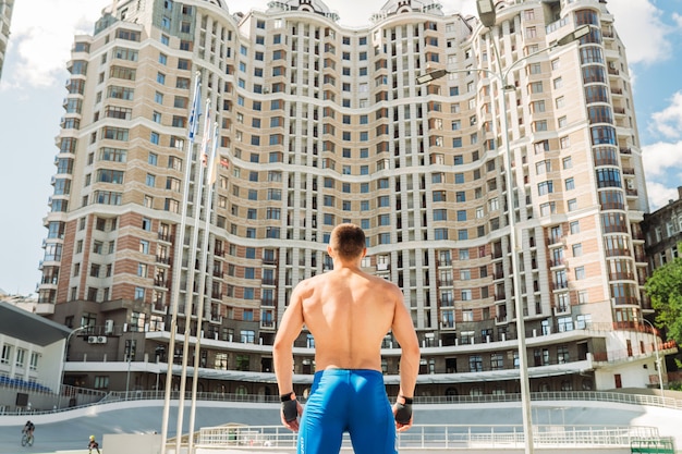 Muscular guy posing outdoors. Portrait of a handsome man blue shorts.