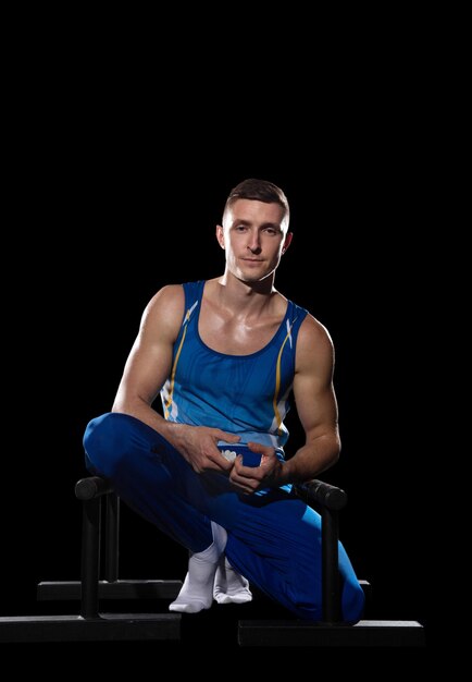 Muscular male gymnast training in gym flexible and active caucasian fit guy blue sportswear