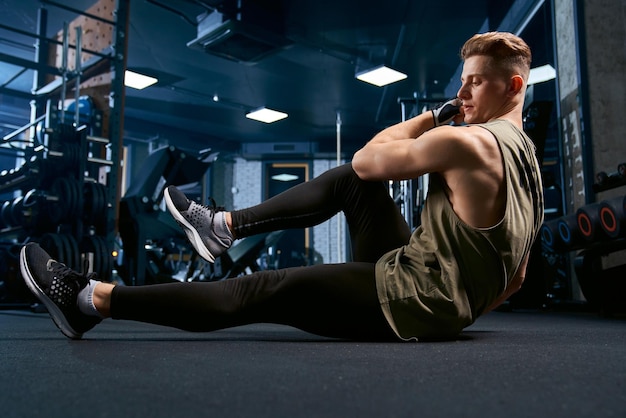 Free photo muscular man doing crunches on floor